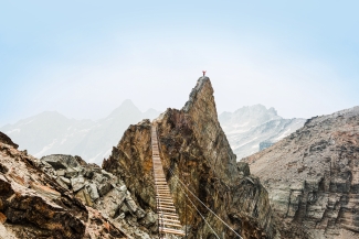 A person climbing to the top of a mountain